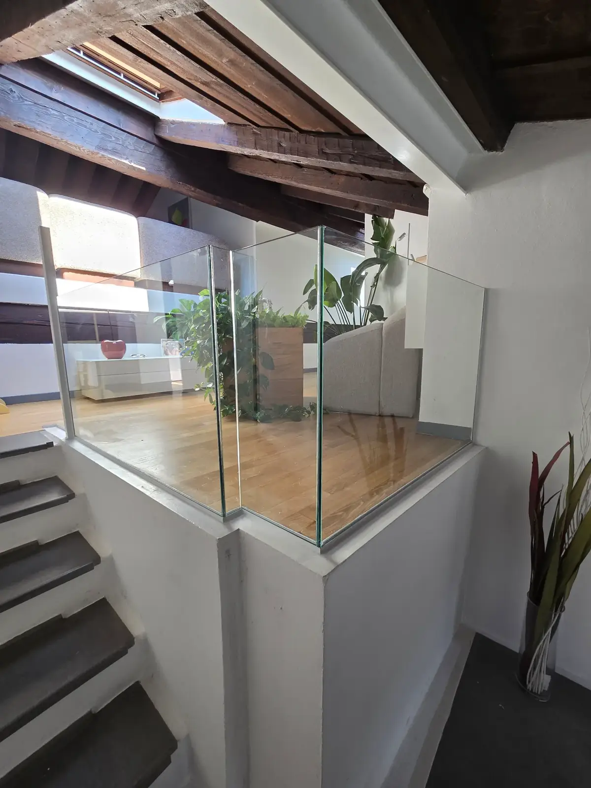 Parapetto tutto vetro realizzato da Jenius, mansarda con travi in legno a vista